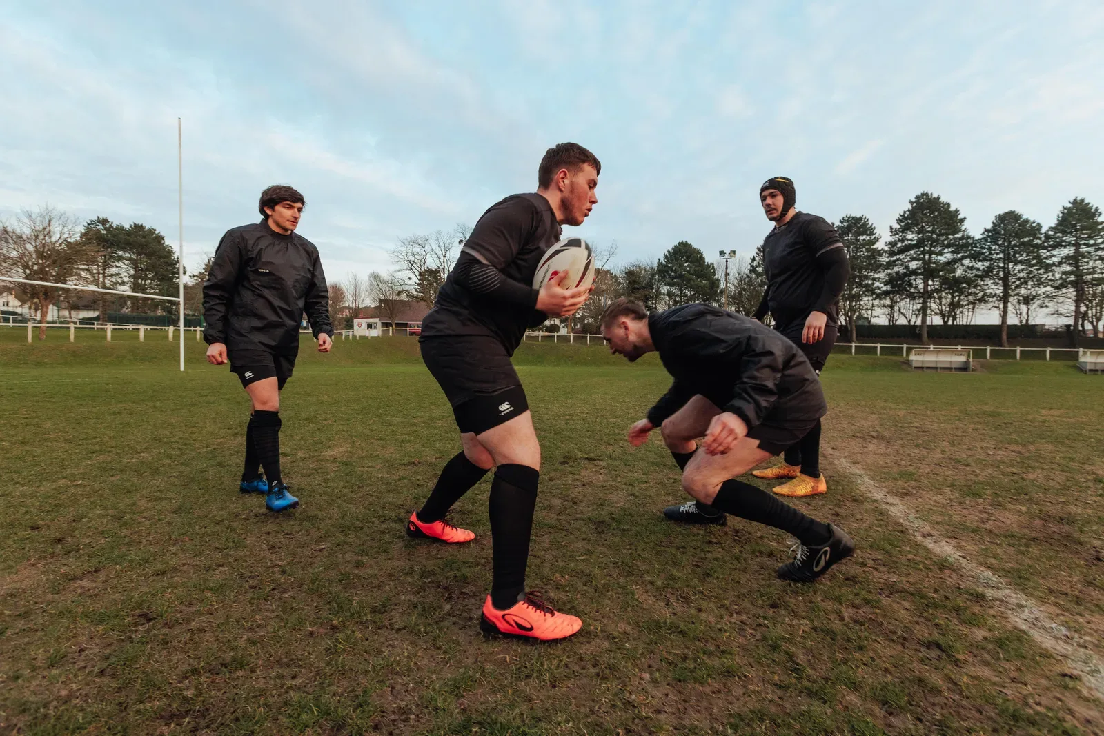 Footy players running a ball drill at training