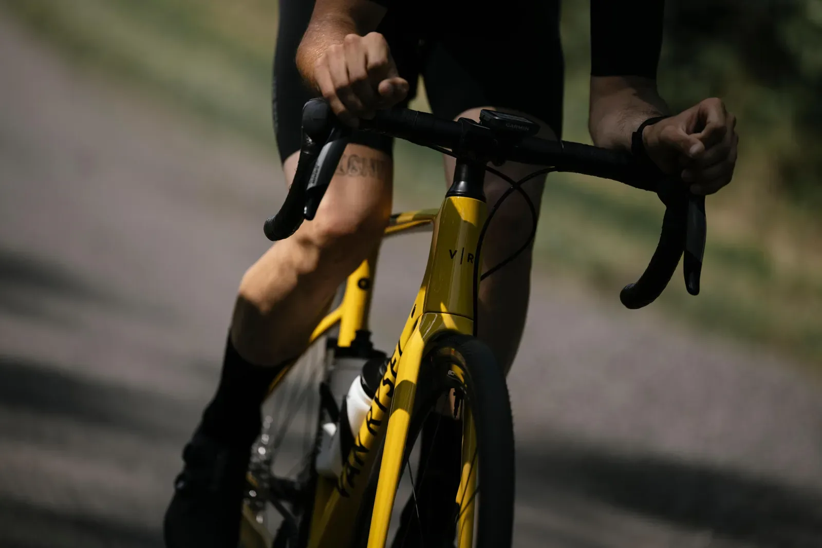 Cyclist hands on the drops of a yellow road bike