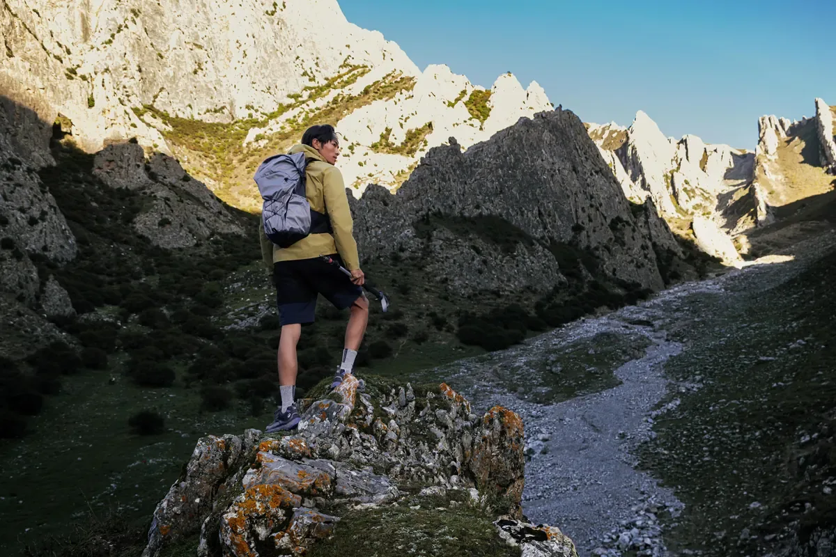 Hiker standing on a rocky outcrop looking along a steep rocky gorge