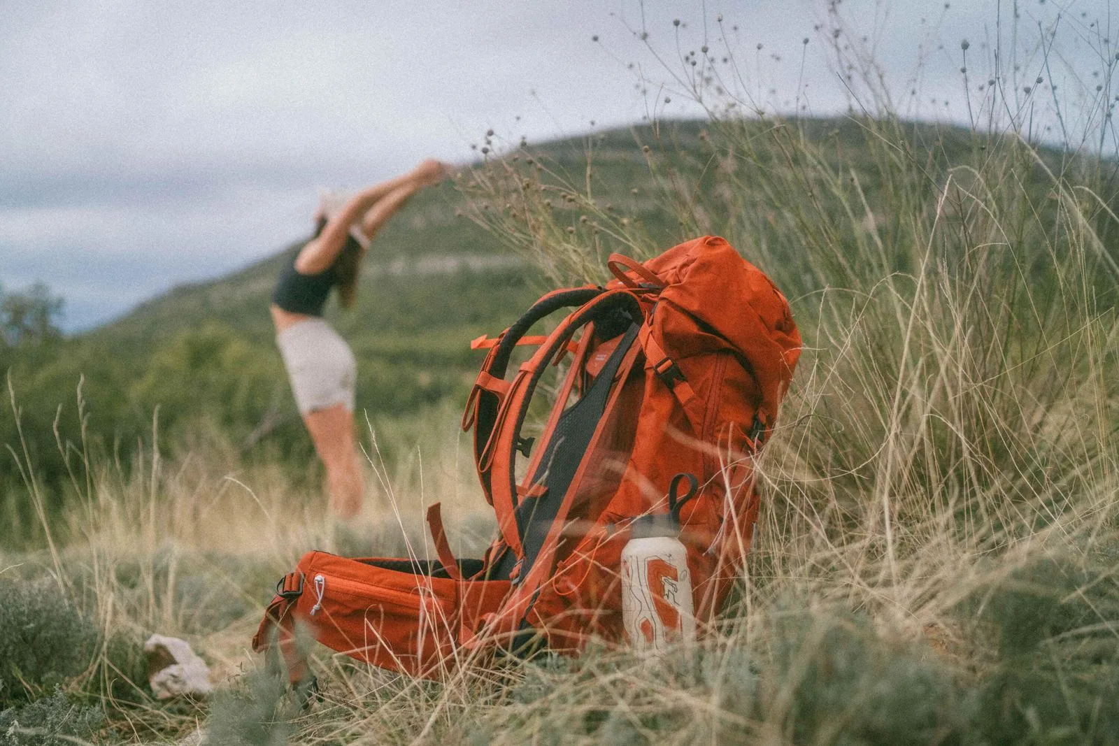 Hiking backpack resting in long coastal grass