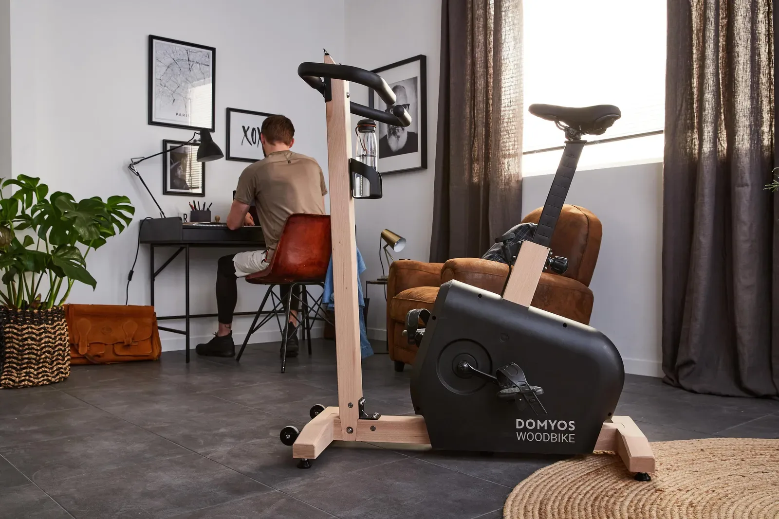 Man working at a desk in a home office beside an exercise bike