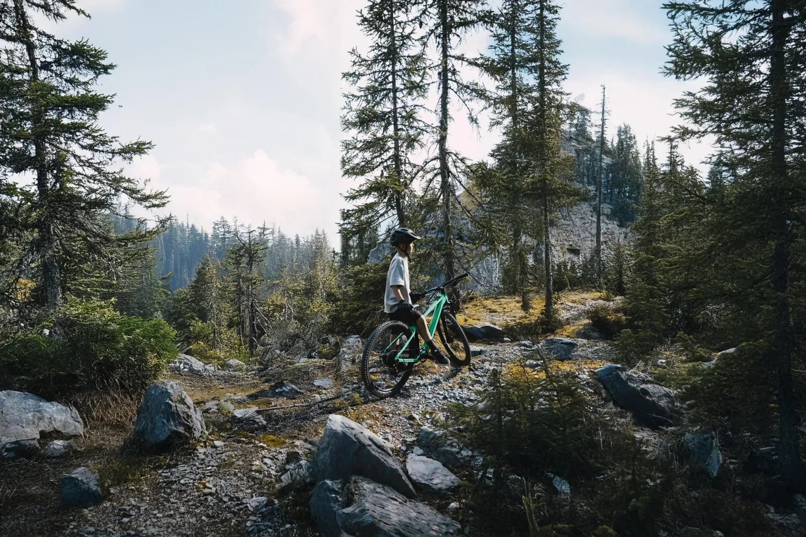 Mountain biker on a rocky trail in an alpine forest