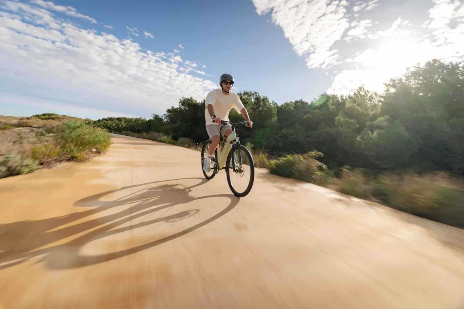 Rider in a helmet enjoying an easy bike ride along a sunny gravel path