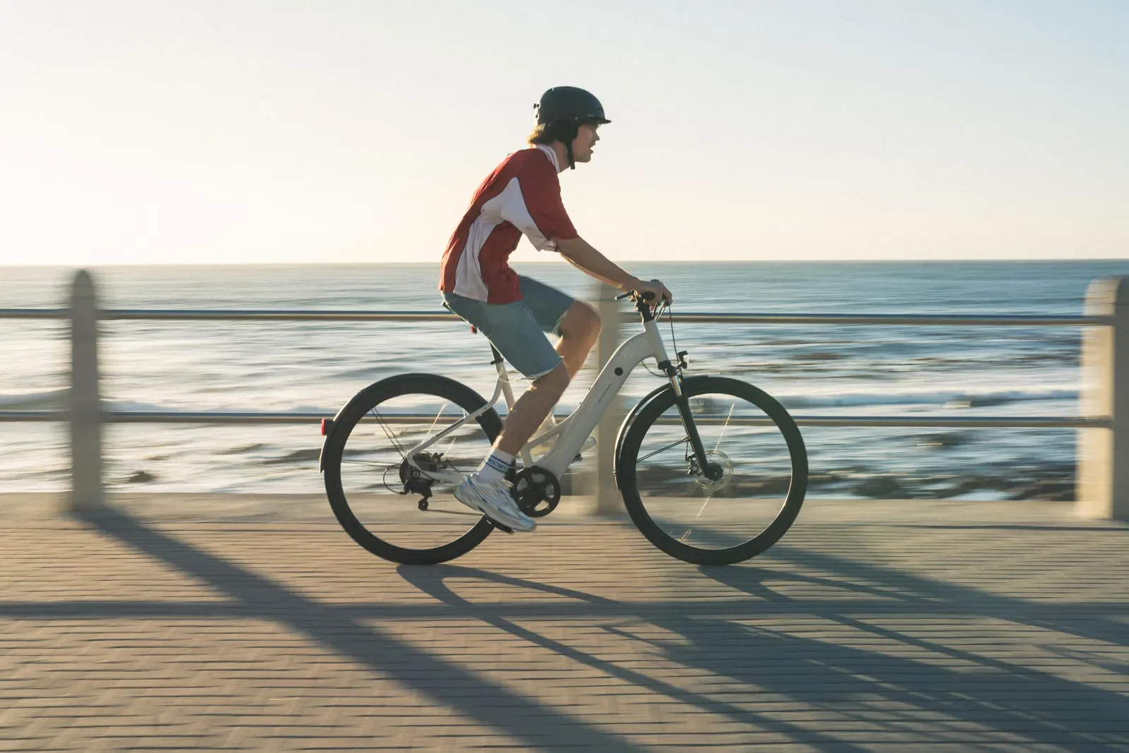 Rider on an e-bike along a seaside promenade