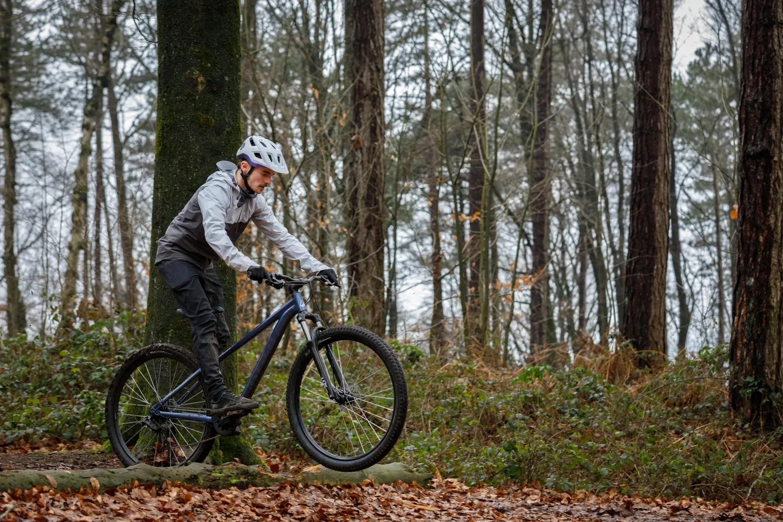 Rider on a hardtail mountain bike in a leafy forest