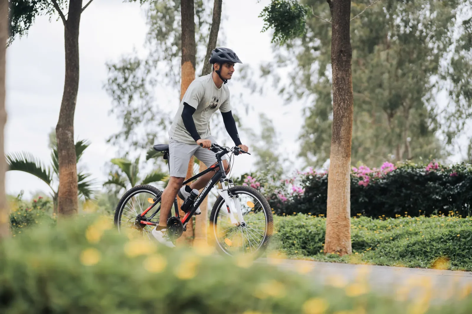 Rider on a hybrid bike on a tree-lined path
