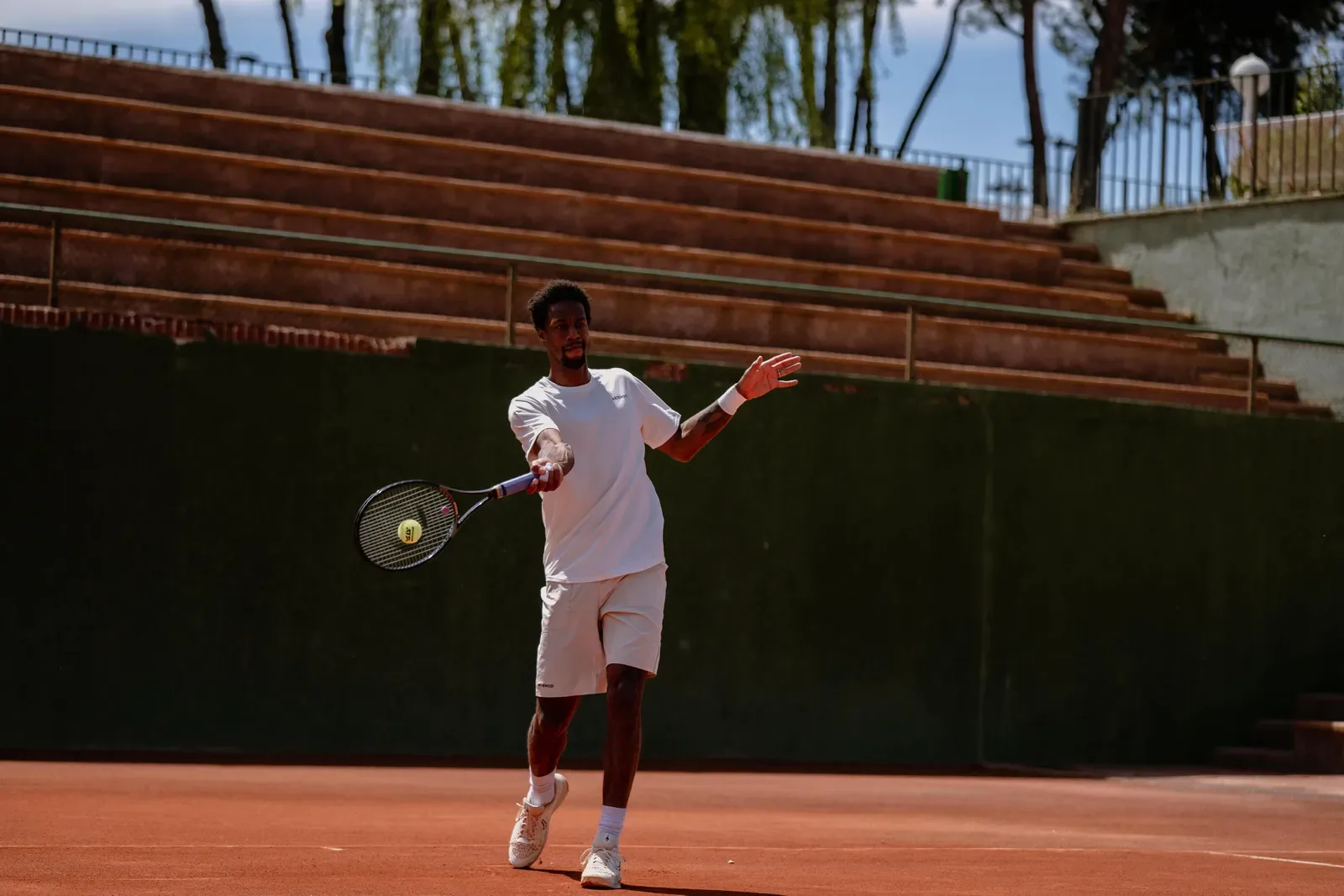 Tennis player hitting a forehand on a court beside empty stands