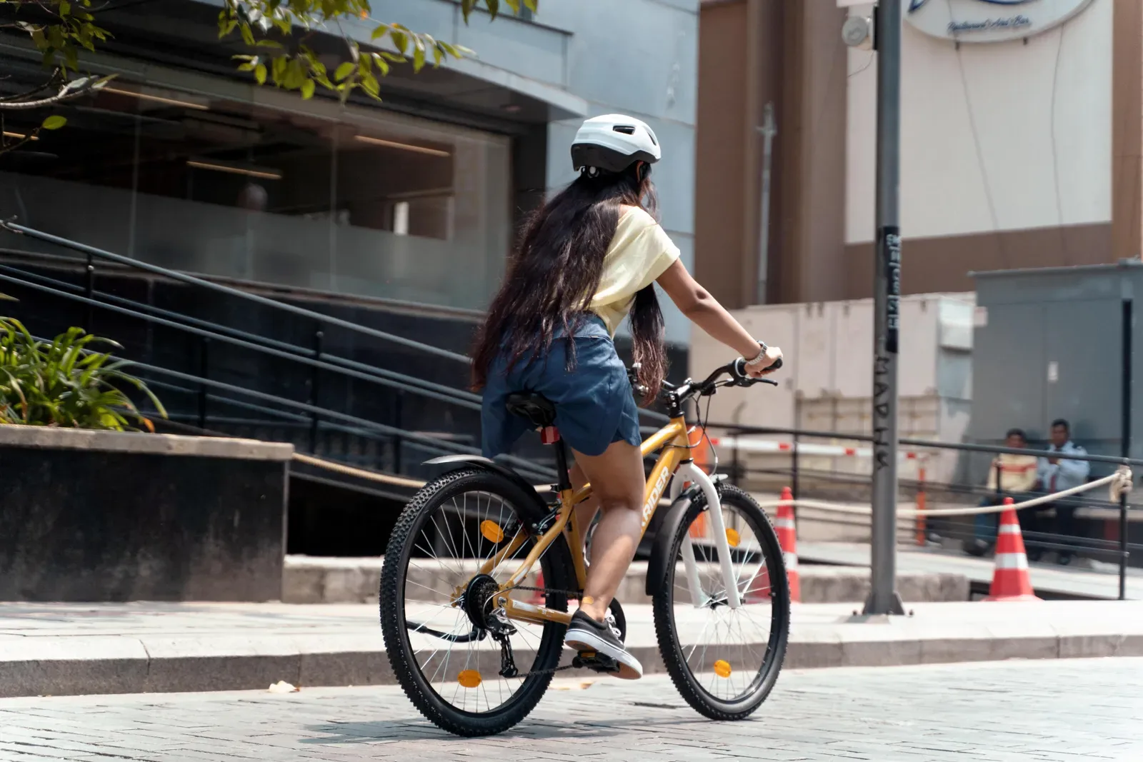 Woman in a helmet riding a bike through the city