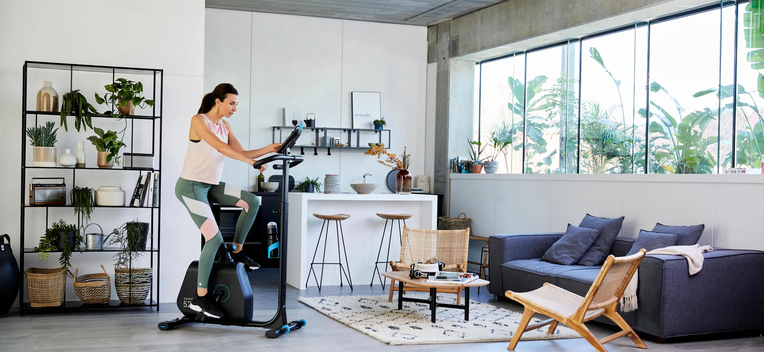 Woman riding an exercise bike in an open-plan living area